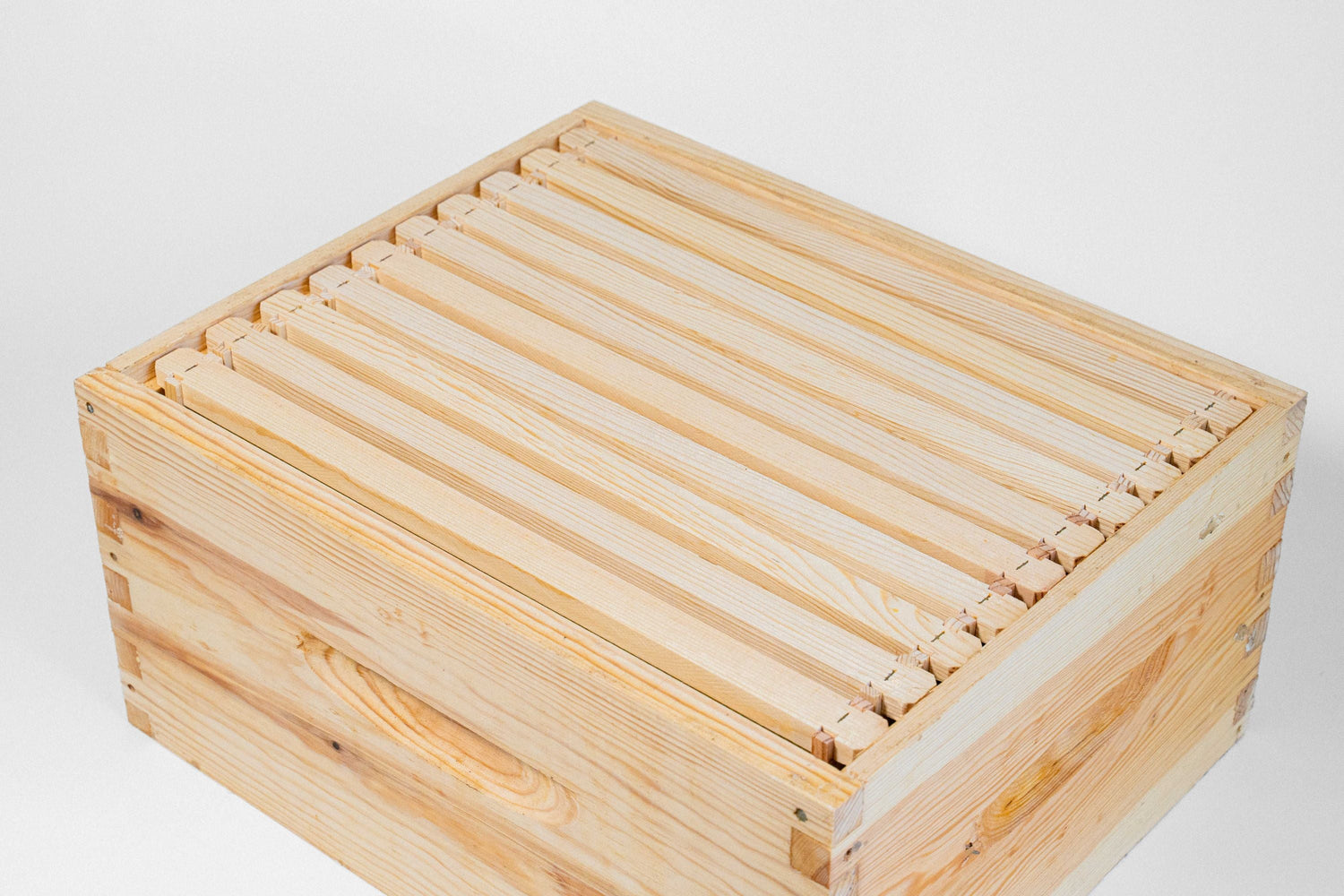 An image of a wooden beehive super with frames