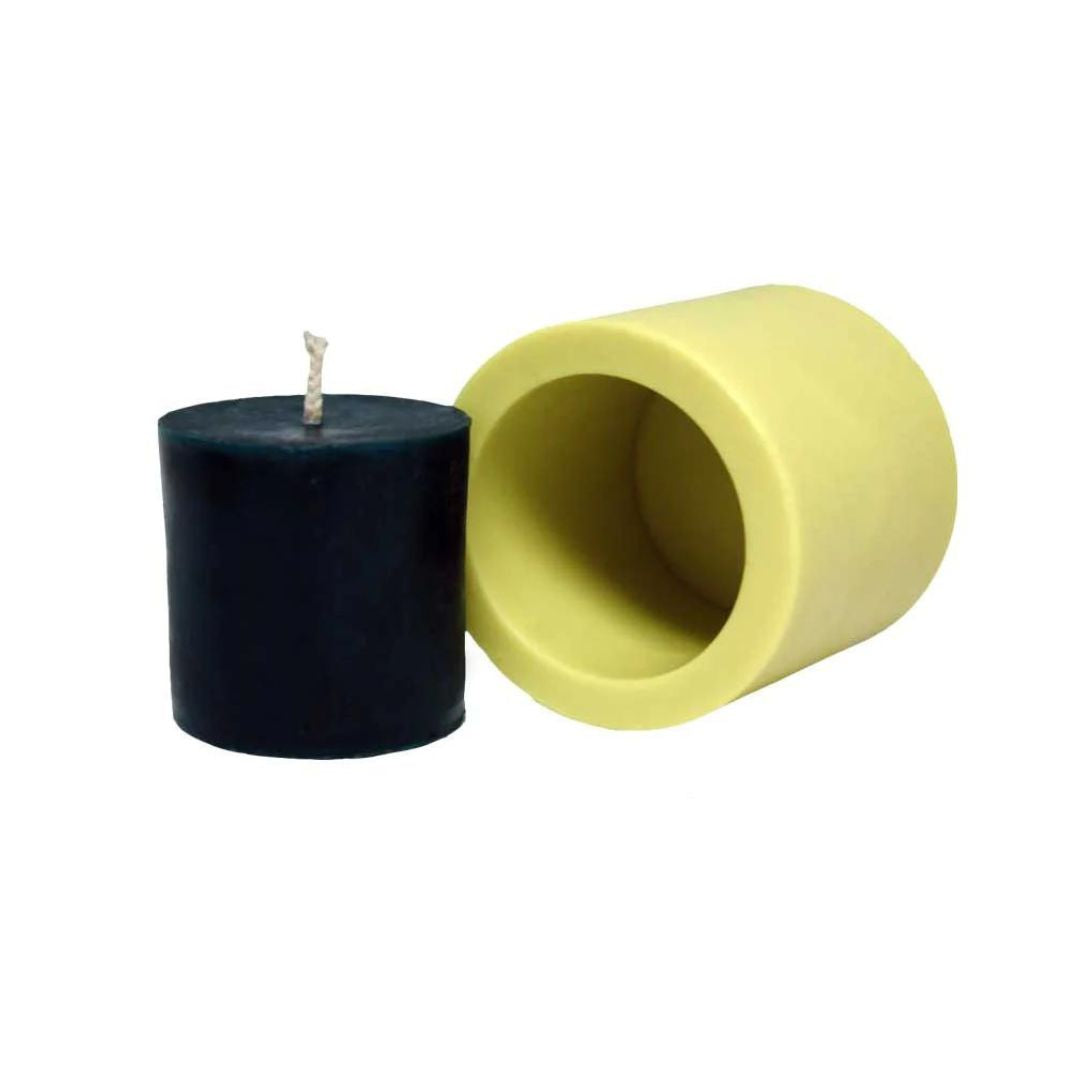 A cylindrical candle mold alongside a 3-inch by 3-inch candle that was made using the mold, displayed against a white background.