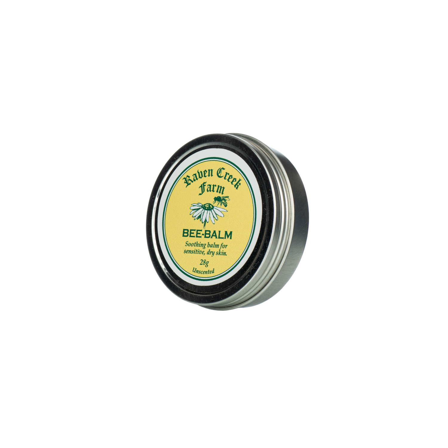 A tin container labeled 'Raven Creek Farm Bee-Balm' with a green and yellow color scheme, indicating it is a soothing balm for sensitive, dry skin, on a white background