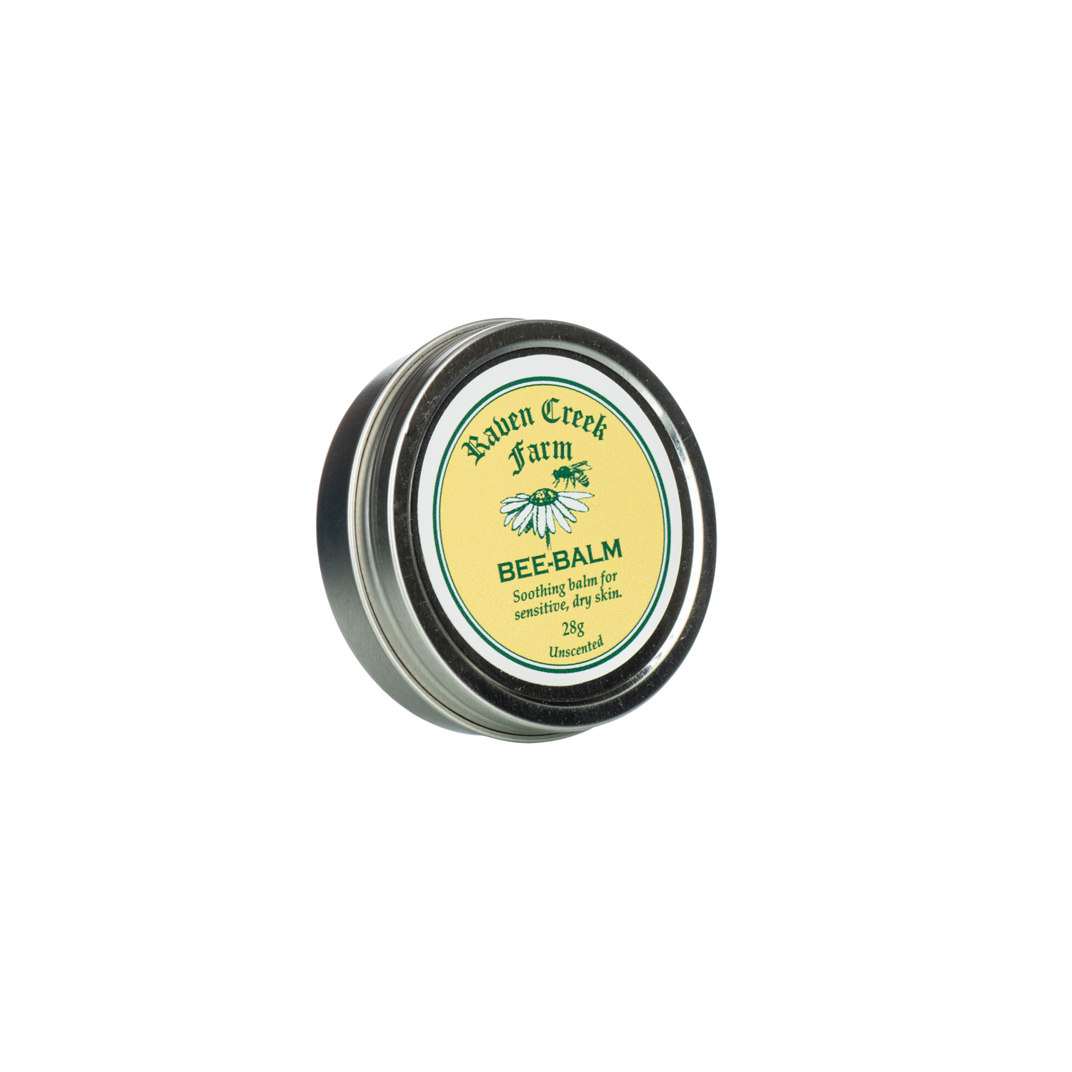 A tin container labeled 'Raven Creek Farm Bee-Balm' with a green and yellow color scheme, indicating it is a soothing balm for sensitive, dry skin, on a white background