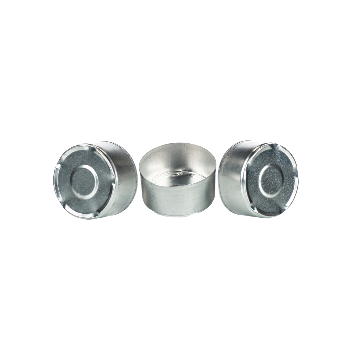 Three metal tealight candle cups, one sitting flat and two slightly tipped up on a white background