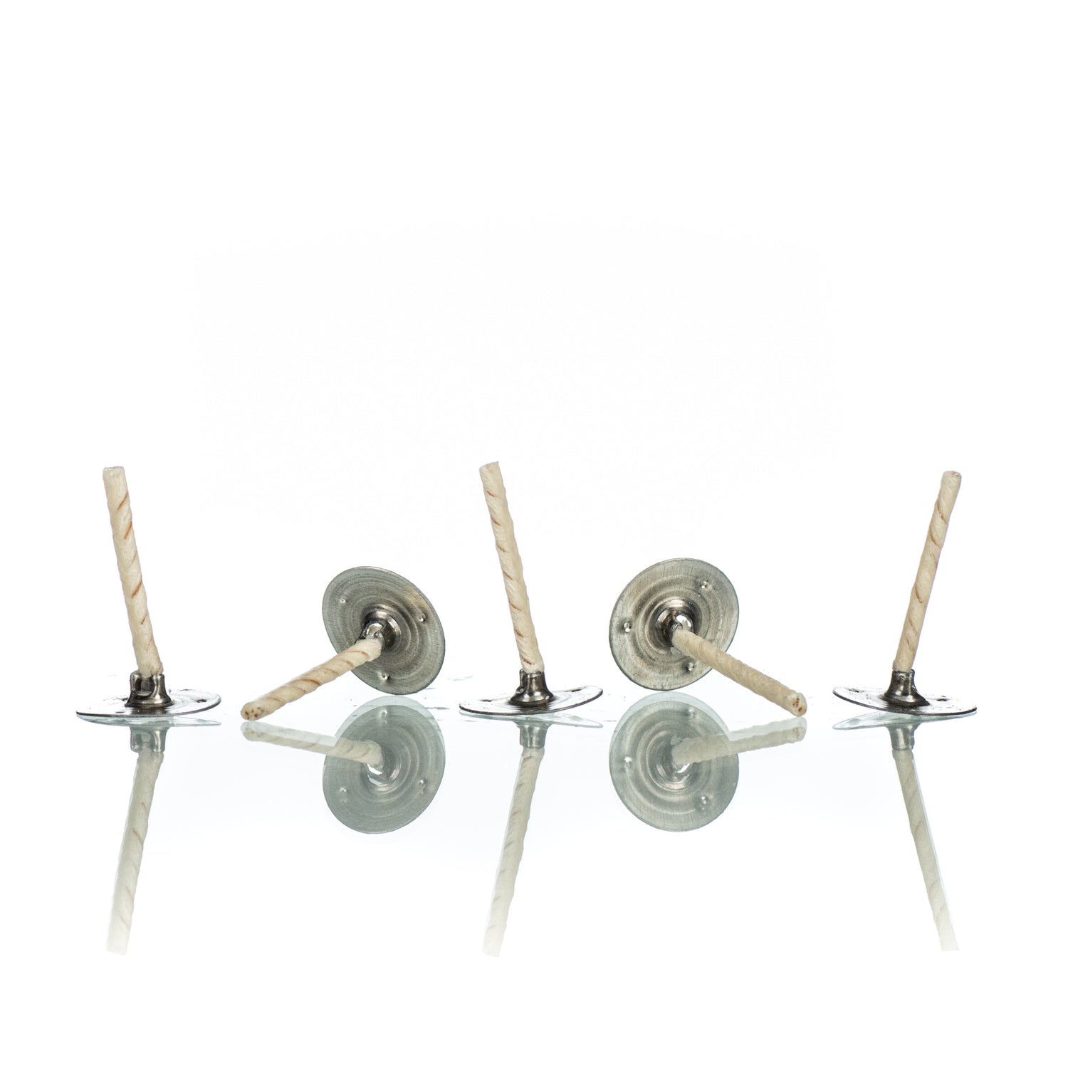 Five white tealight candle wicks with silver wick tabs on a white background