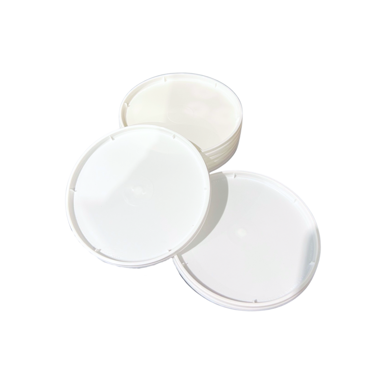 stack of white plastic round lids on a white background