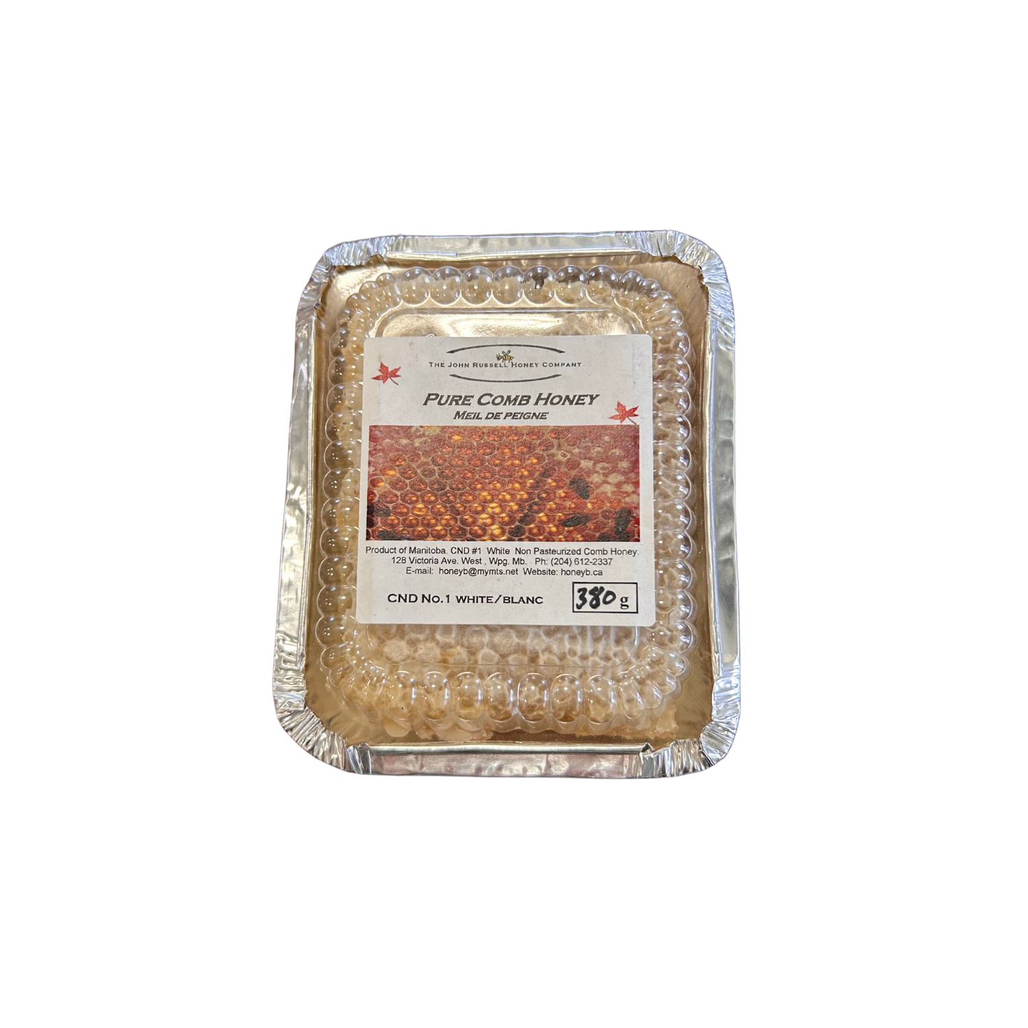 An aluminum container with a clear plastic lid with a block of pure comb honey on a white background