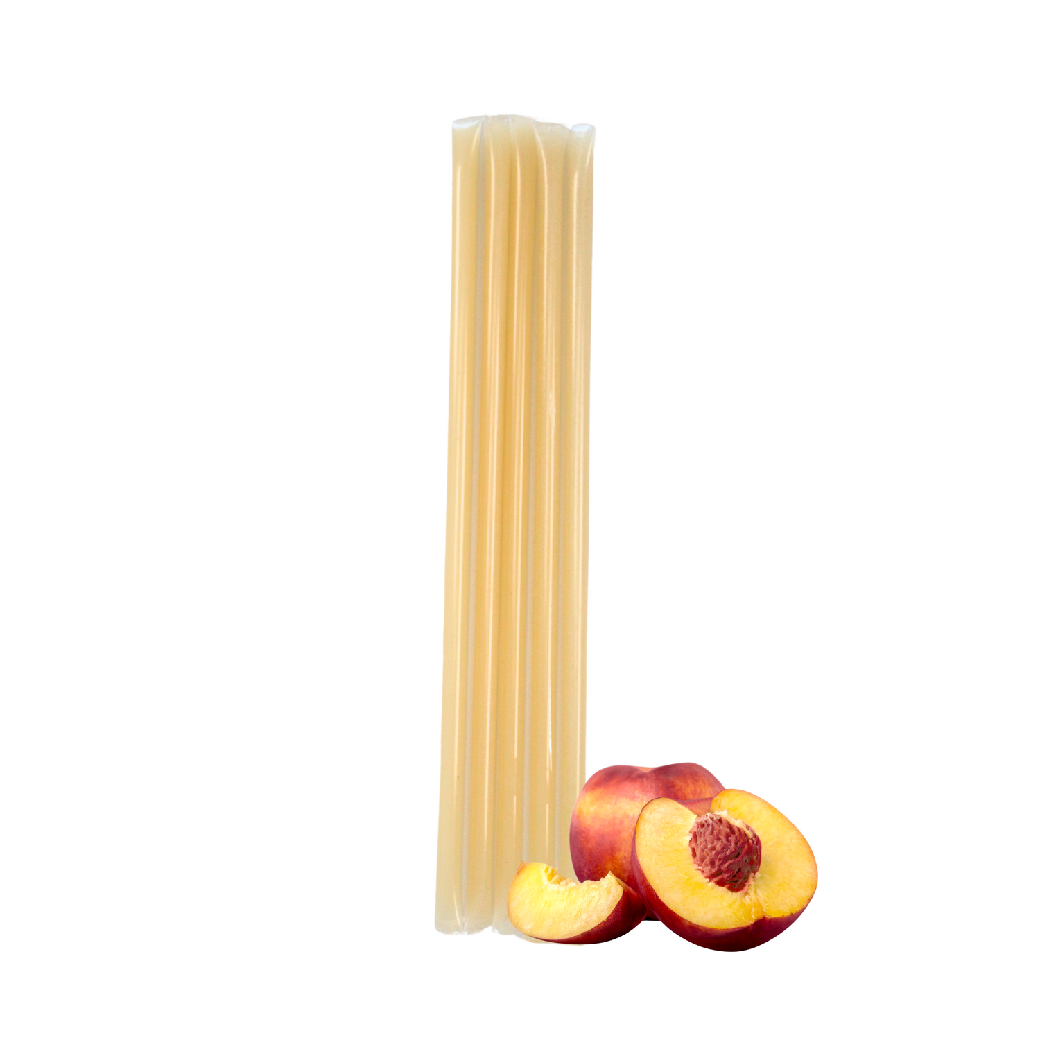 Five peach creamed honey stixs standing upright beside a cluster of peach pieces on a white background.