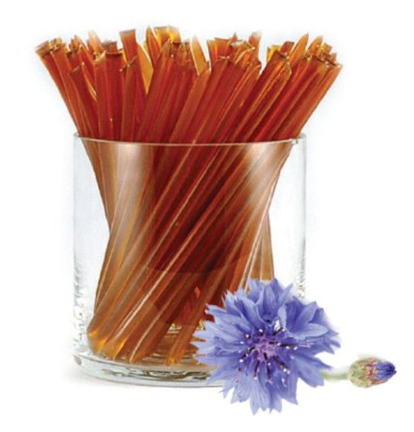 A glass jar of liquid honey stixs, in the flavour clover on a white background.