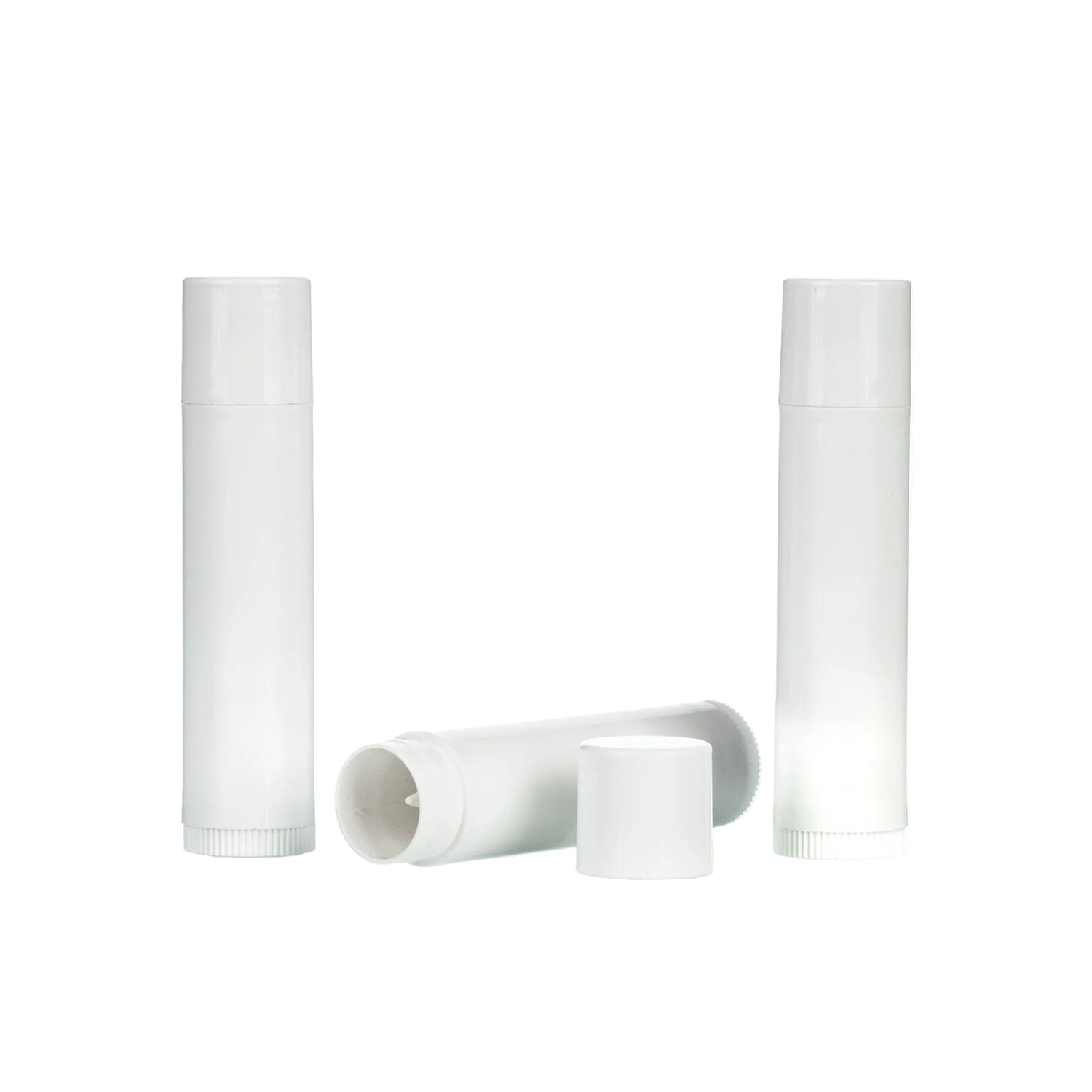 Three white, cylindrical lip balm containers, two stand upright while one lies down with its cap off on a white background