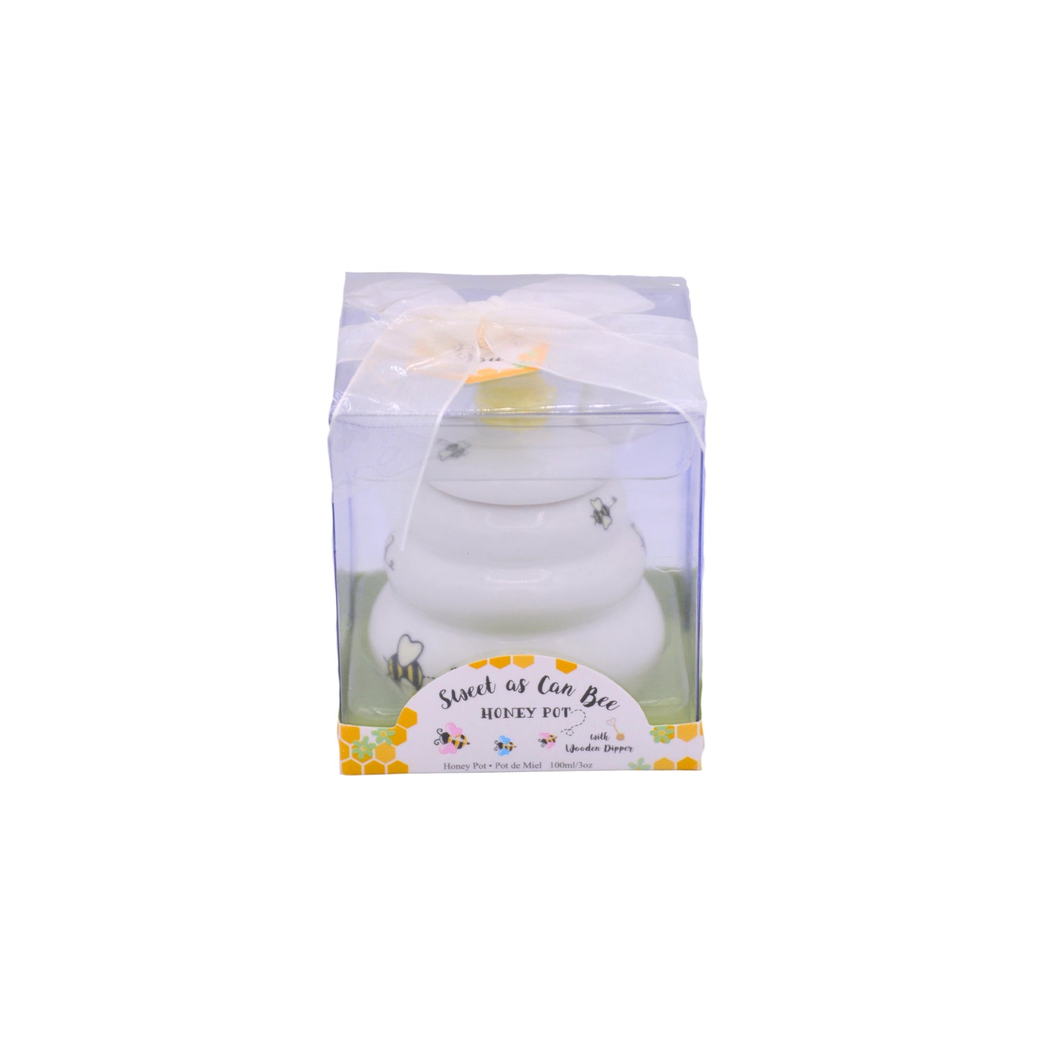 A white ceramic honey pot figurine inside a clear plastic gift box with a white ribbon, labeled 'Sweetest of All Bee HONEY POT'.