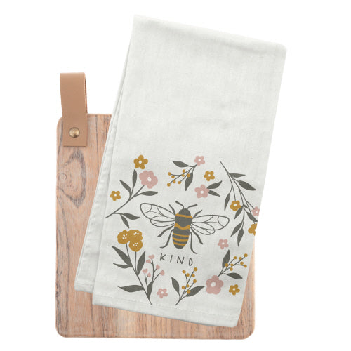 A white towel with a bee illustration surrounded by flowers and leaves, and the word