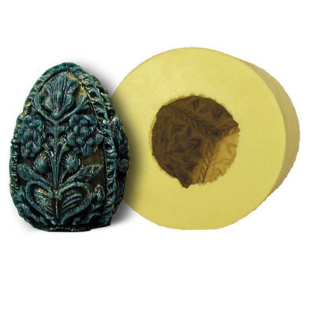 A carved egg-shaped candle mold with intricate details alongside a candle created using the mold on a white background