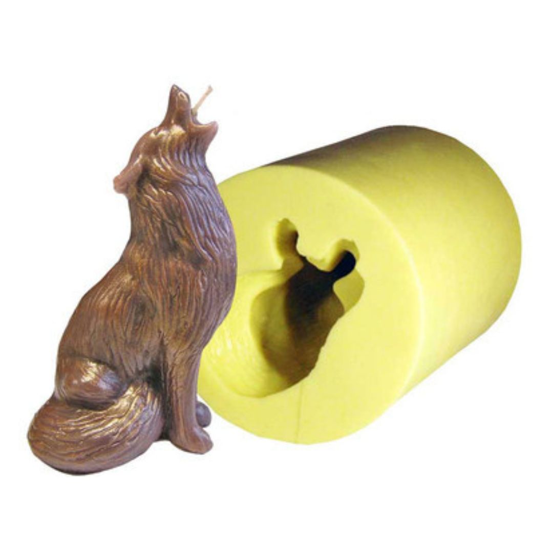 A candle mold in the shape of a howling wolf next to the corresponding solid wax candle shaped as a wolf on a white background