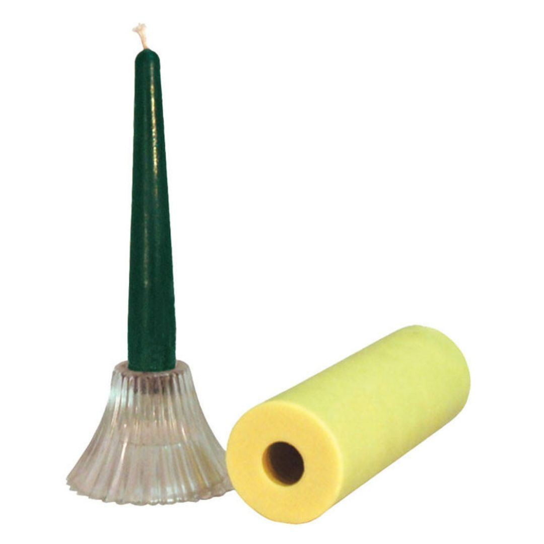Long green candle in a candle holder with a yellow cylindrical candle mold on a white background