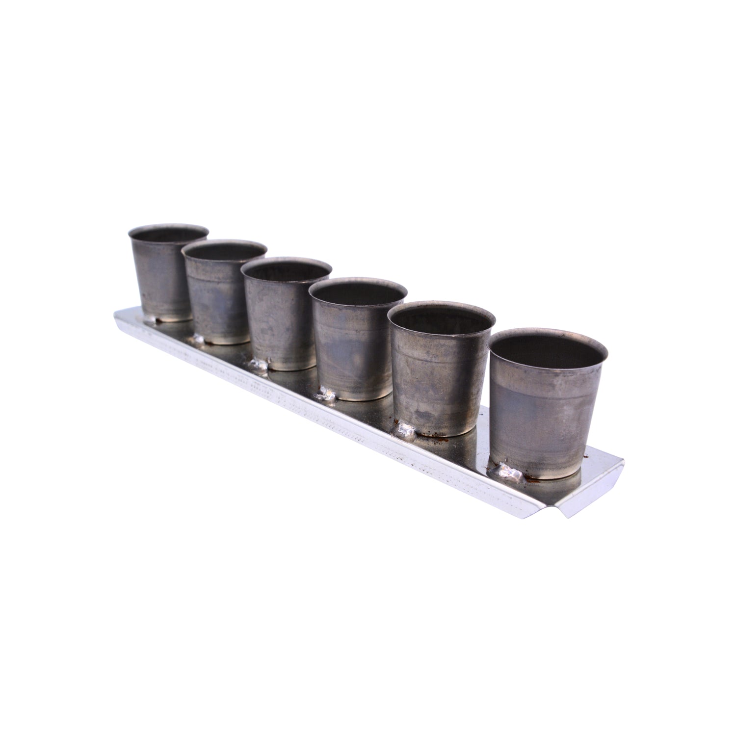 A tin votive mold used to make six votive candles on a white background