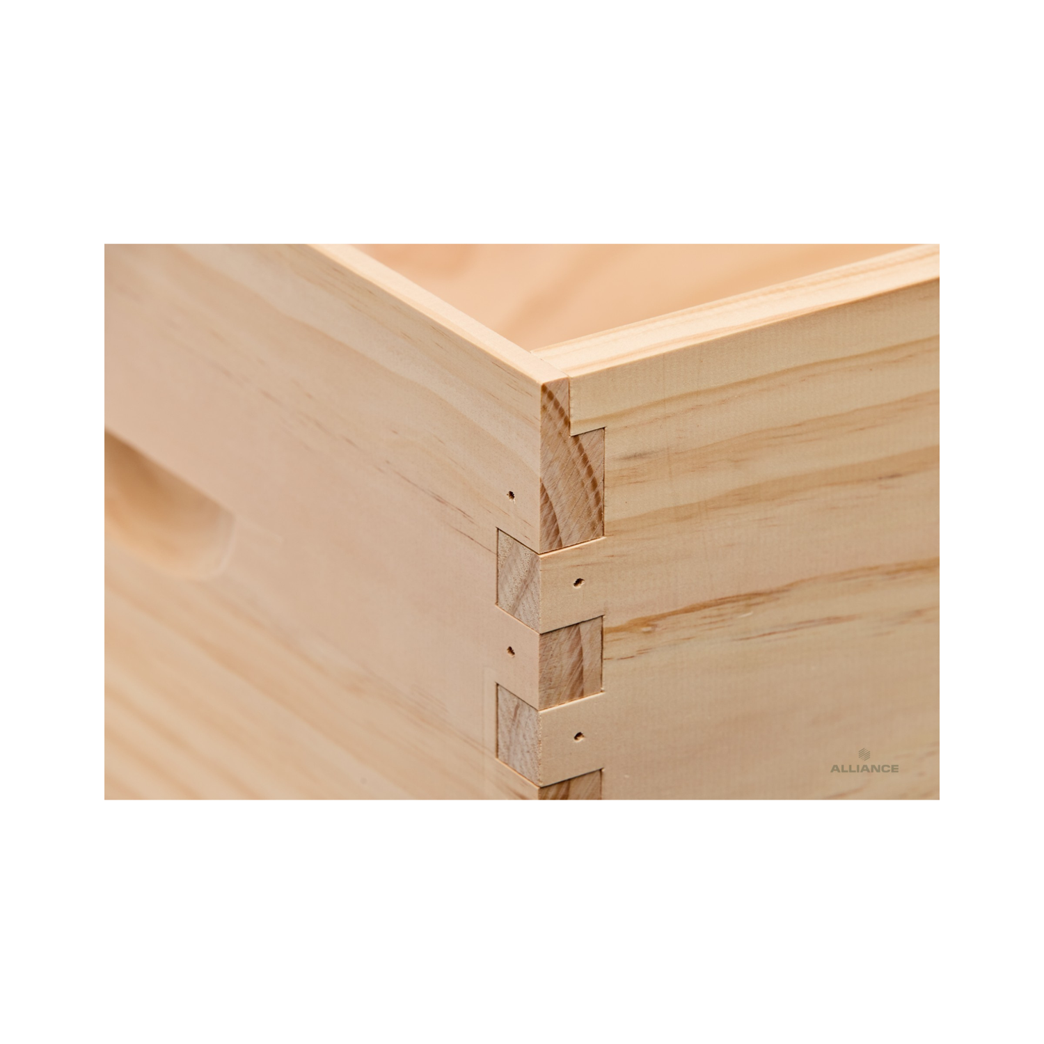 Close-up of an Alliance wooden beehive box corner showing dovetail joints on a white background