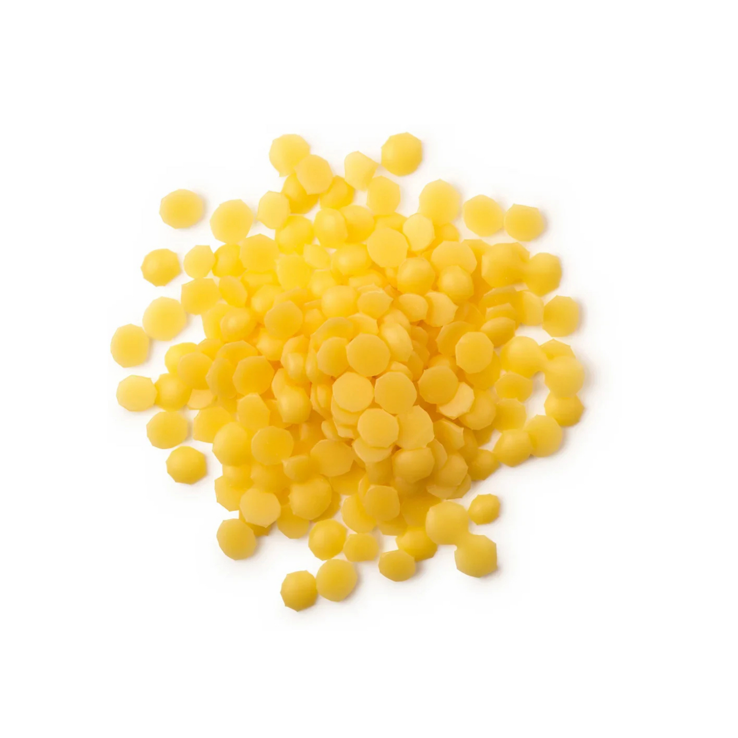 A pile of yellow beeswax pastilles on a white background.