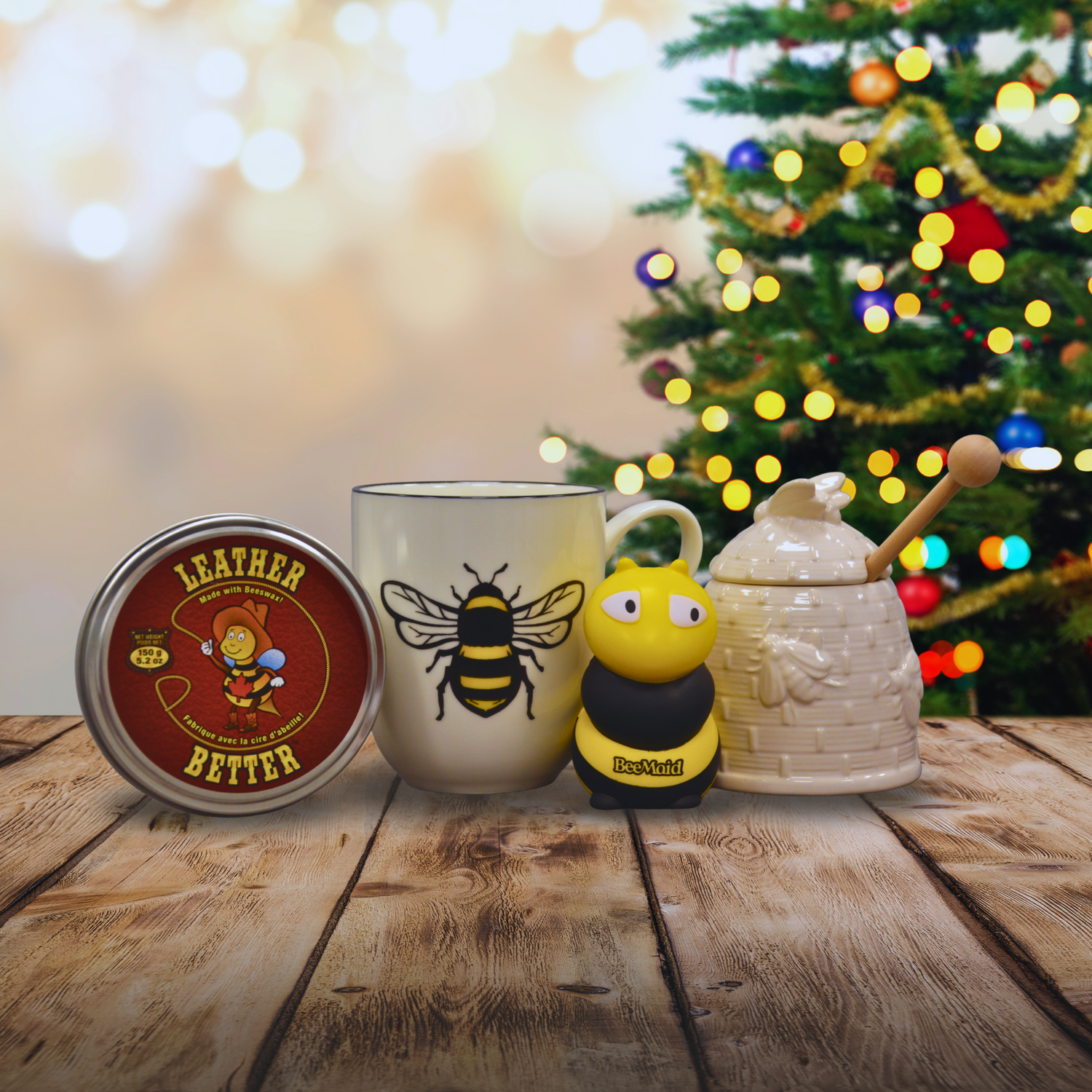 A bundle of bee-inspired products including a squeezable bee, a honey pot, and a mug on a festive background