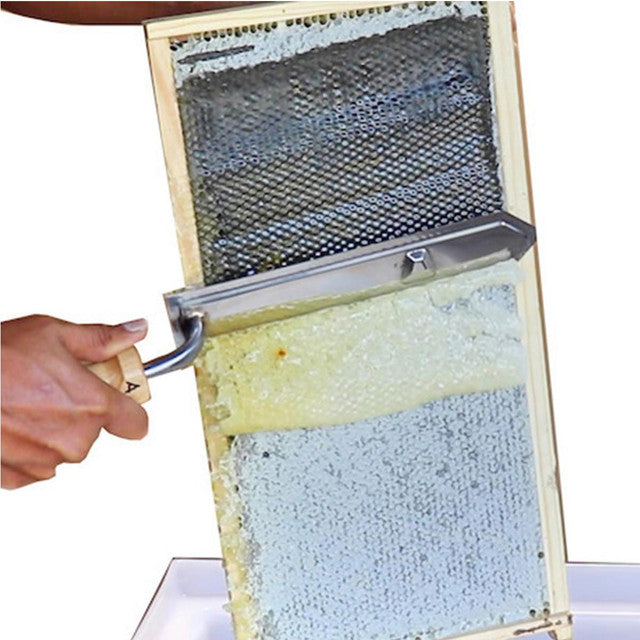 A visual of the metal uncapping knife being used on a frame, displayed on a white background
