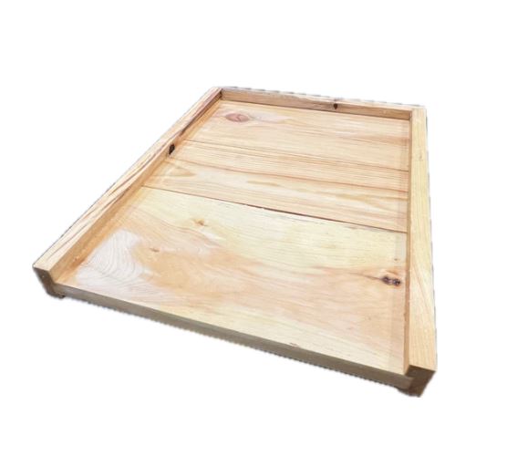 A wooden waxed hive bottom for beehives, showing a landing area and hive floor.