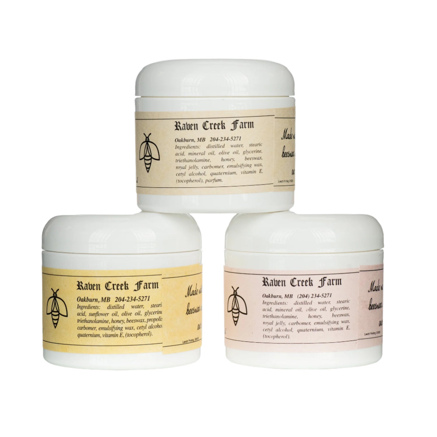 Three jars of Raven Creek Skin Cream with different labels indicating variations with royal jelly and propolis. The jars are white with cream-colored labels and are pictured against a white background.