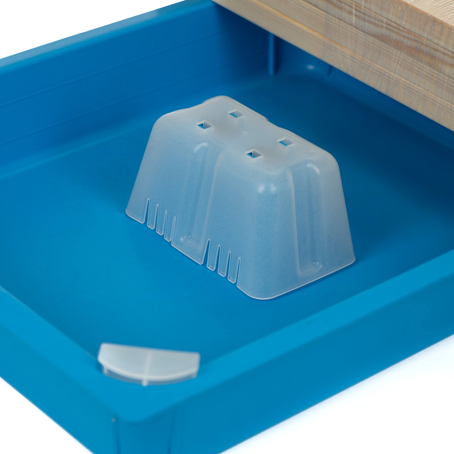 Close up of a blue top feeder with a patented corner access system, accompanied by corner caps and a chimney, displayed alongside a wooden frame.