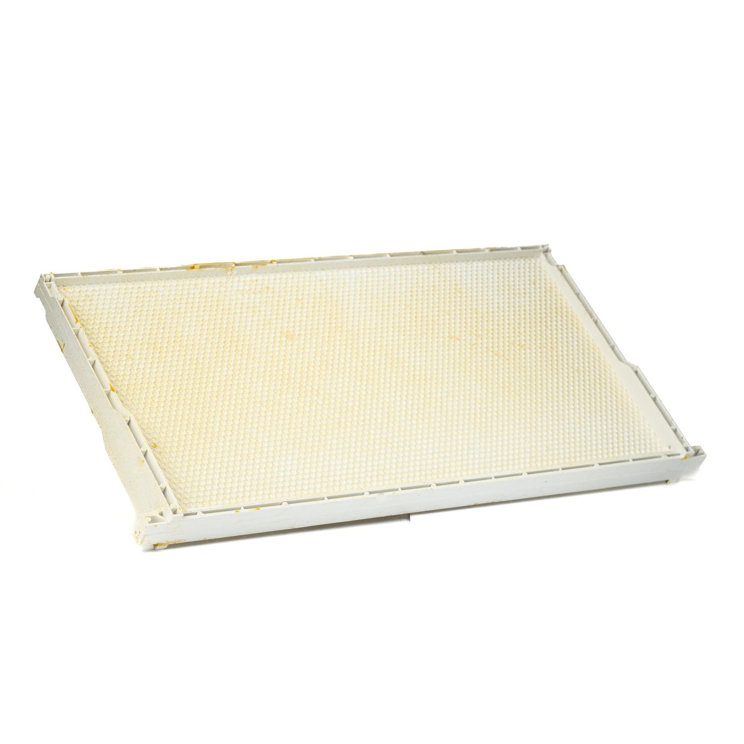 A side view of a white wax-coated plastic frame and foundation for beekeeping, designed to fit into Langstroth supers.