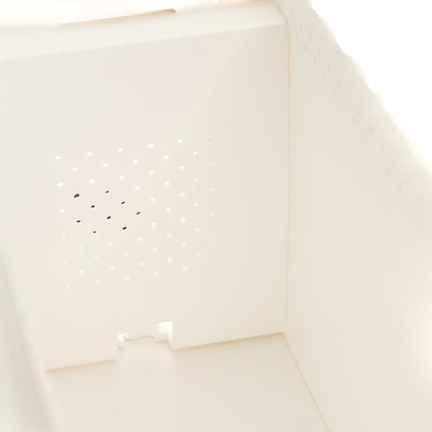A close up of a white, corrugated plastic nuc box displaying the improved ventilation.
