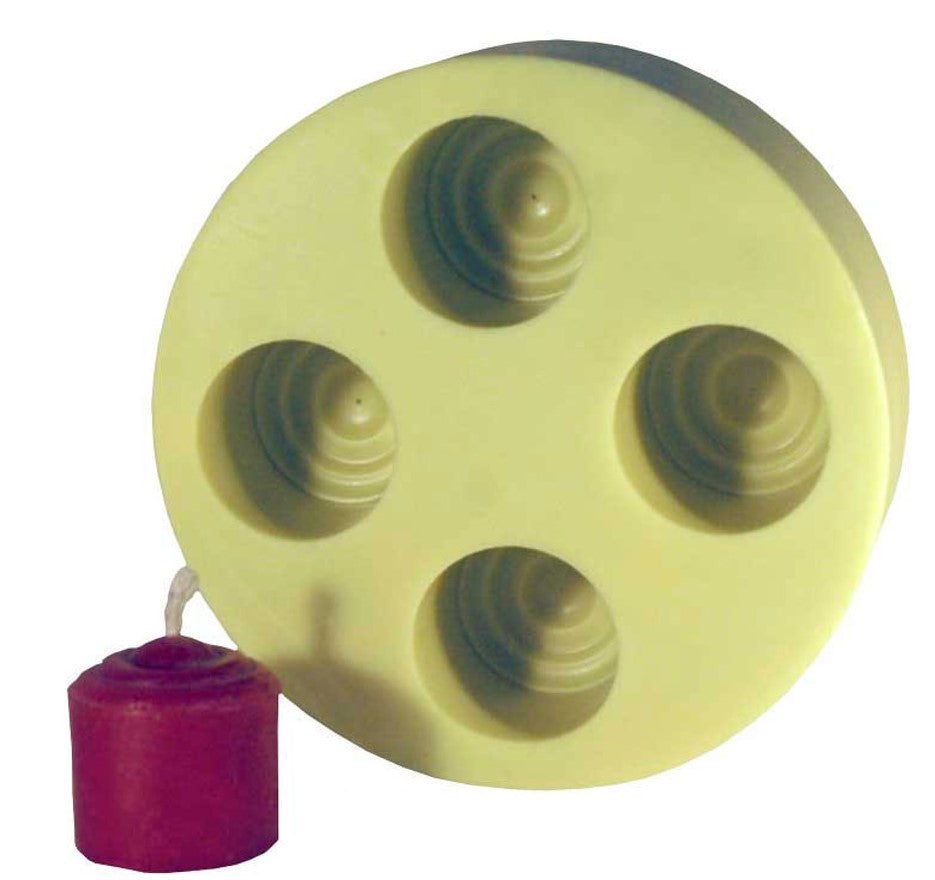 A yellow candle mold with four circular indentations, alongside a small red votive candle on a white background