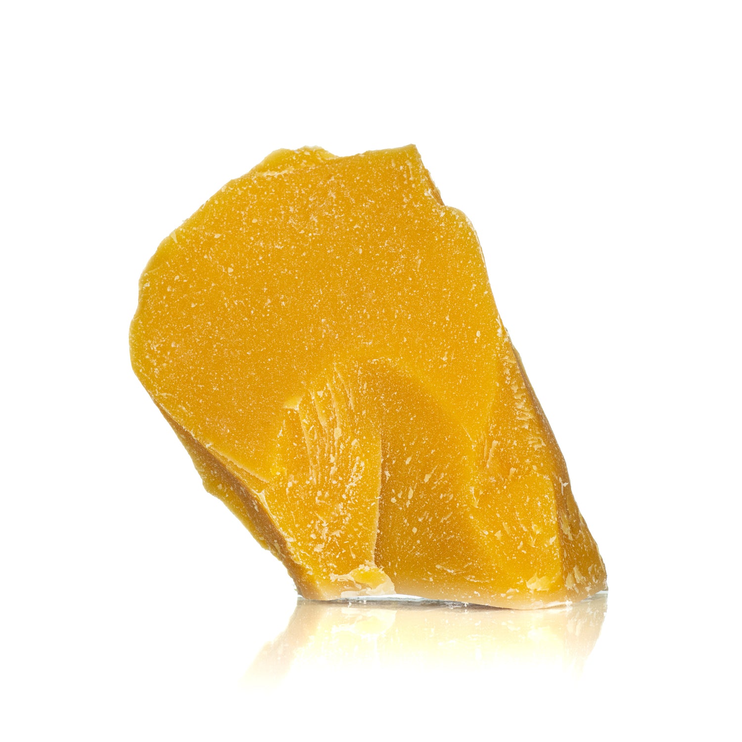 Chunk of yellow beeswax capping on white background