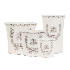 Set of four decorative planters with floral and bee patterns on a white background