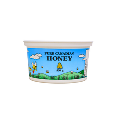 A 500-gram plastic container with a white lid, featuring a label with the text 'PURE CANADIAN HONEY' and an illustration of bees and a honeycomb.