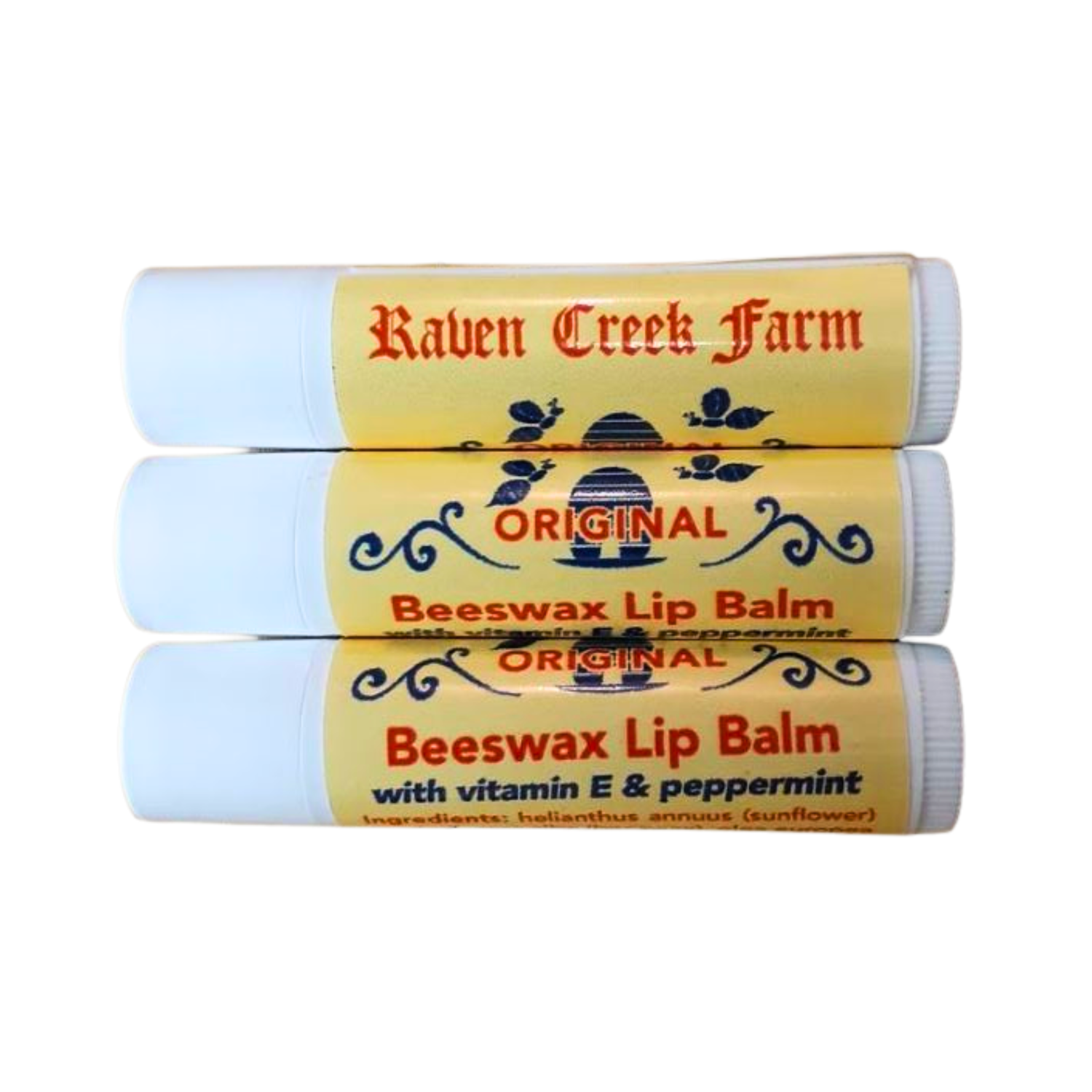 Three tubes of Raven Creek Farm beeswax lip balm on a white background