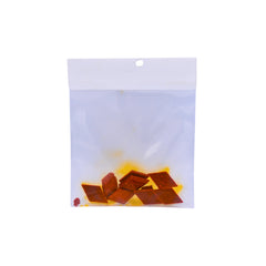 A clear plastic bag with several orange coloured dye buds shown on a plain white background.