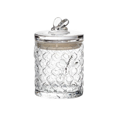 A glass honeycomb jar with a matching glass on a white background. 