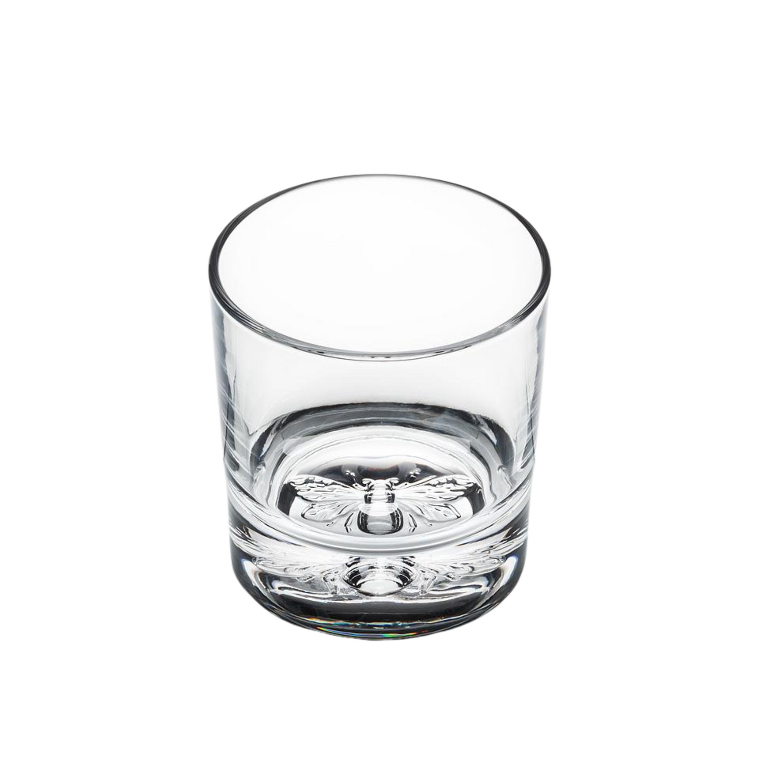 A glass tumbler with a bee design on the bottom on a white background