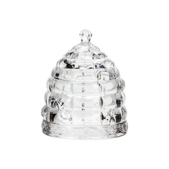 A glass honeypot beehive on a white background