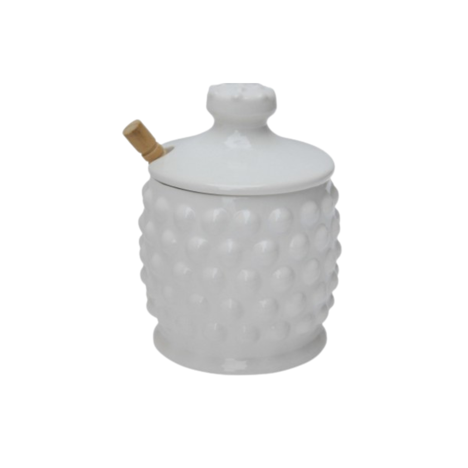 A white ceramic honey jar with a raised bubble texture on the sides, a matching lid, and a small wooden honey dipper inserted through a slot in the lid.