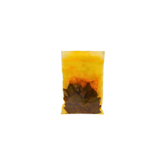 A small clear plastic pouch containing brown dye chips shown on a plain white background.