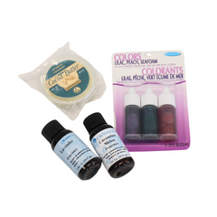 A close up of the three soap colors, soap scents, and cocoa butter additive on a white background
